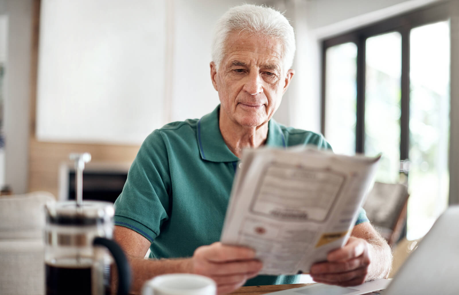 Man reading an obituary in a newspaper in the morning