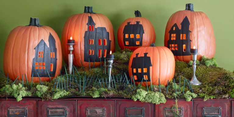 Pumpkins with houses carved on it