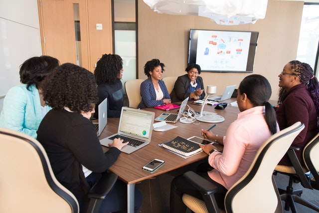 Female African-American employees discussing change management plan during a board meeting