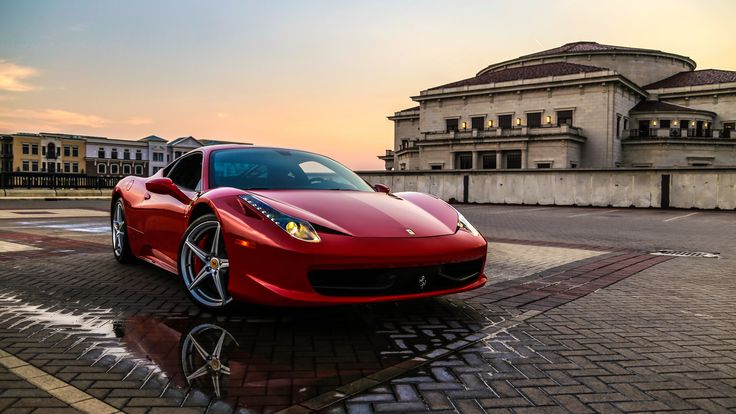A beautiful red luxury car in front of a palace